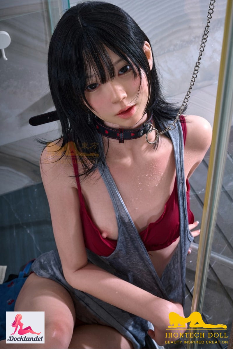 Bondage sexdocka Kurumi från Irontech Doll, sitter i duschen med svart hår, röd bikini och våt grå topp, närbild i badrumsmiljö.